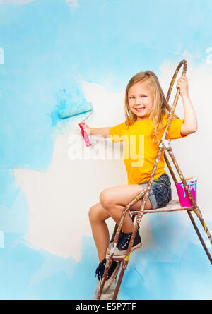 Kleines Mädchen sitzt auf einer Metallleiter Stockfoto