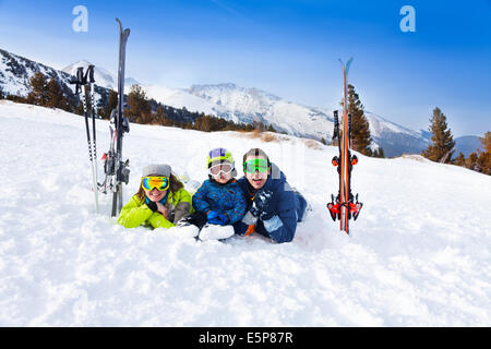 Happy Family im Ski-Masken, die Verlegung auf Schnee Stockfoto