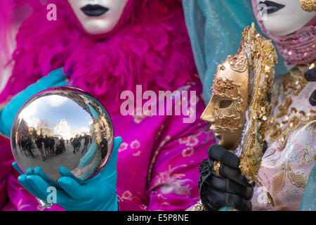 Nahaufnahme von Frauen, die sich in silberne Kugel reflektierende hand Mask und San Zaccaria square während des Karnevals in Venedig. Stockfoto