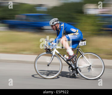 Alberta, Kanada. 4. August 2014. Ein Radler fährt auf einer Runde des Criterium in der Gemeinde Bowness am Montag, den 4. August 2014, auf einer Stadtstraße. Dieses Radrennen markiert den 13.. Jahrestag der Tour de Bowness mit drei Rennen. Calgary, Alberta, Kanada. Quelle: Rosanne Tackaberry/Alamy Live News Stockfoto