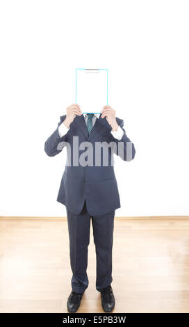 Geschäftsmann im Anzug eine leere Tafel statt den Kopf halten. Männliche Hände halten eine Blindplatte weiß auf weißem Hintergrund Stockfoto