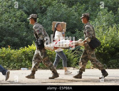 Ludian, der chinesischen Provinz Yunnan. 5. August 2014. Retter übertragen ein verletztes Kind in der Longtoushan Stadt von Ludian County, der südwestlichen chinesischen Provinz Yunnan, 5. August 2014. Mindestens 398 Menschen sind getötet worden, nachdem eine Erdbeben der Stärke 6,5 die Provinz Sonntagnachmittag rasselte. Bildnachweis: Xing Guangli/Xinhua/Alamy Live-Nachrichten Stockfoto