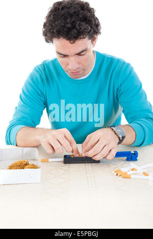 Mann, rollende Zigaretten mit frischem Tabak, seine Gelüste und Gewohnheit zu rauchen zu befriedigen Stockfoto