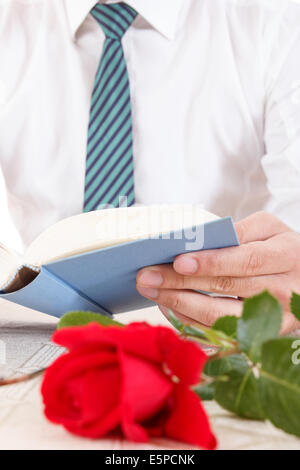 Stillleben mit roter rose und alte Buch Lesebuch mit roten rose neben für Life-Style-image Stockfoto