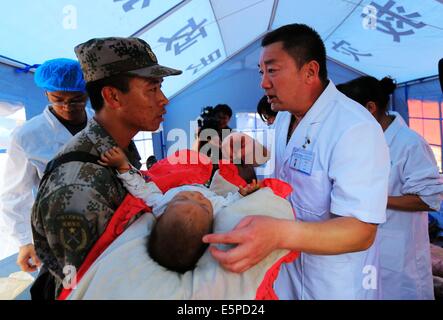 Ludian, der chinesischen Provinz Yunnan. 5. August 2014. Retter übertragen ein Baby in Longquan Dorf Ludian County, der südwestlichen chinesischen Provinz Yunnan, 5. August 2014. Mindestens 398 Menschen sind getötet worden, nachdem eine Erdbeben der Stärke 6,5 die Provinz Sonntagnachmittag rasselte. Bildnachweis: Xing Guangli/Xinhua/Alamy Live-Nachrichten Stockfoto