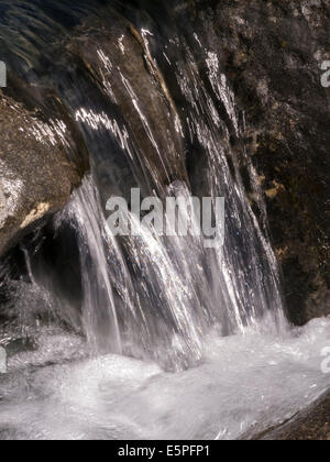 Nahaufnahme der kleinen sonnigen Wasserfall im tosenden Bergbach Stockfoto