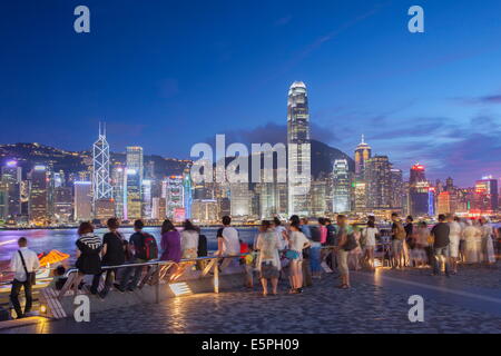 Touristen, die Skyline von Hong Kong Island von Tsim Sha Tsui bei Dämmerung, Hong Kong, China, Asien Stockfoto