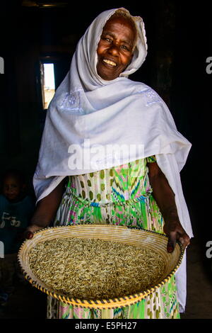 Freundlichen alten Frau mit einem Korb von Mais in einen Türrahmen in der Nähe von Keren, Eritrea, Afrika Stockfoto