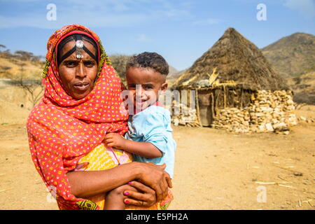 Mutter mit ihrem Sohn vor eine urige Hütte im Hochland von Eritrea, Afrika Stockfoto