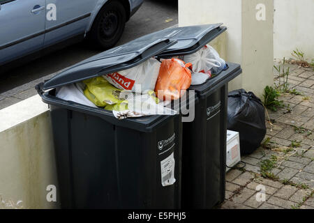 inländische Wheelie Mülleimer überfüllt mit Müll auf Sammlung und Entleerung England uk Stockfoto