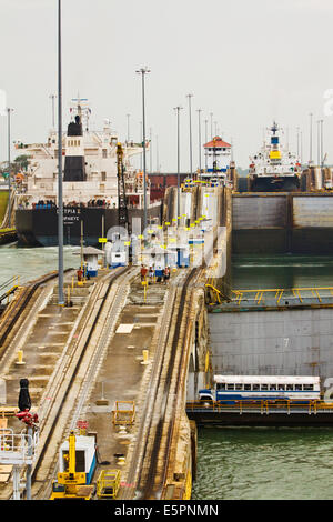 Zwei Schiffe im Gatun Schleusen unterhalb Gatun See mit Schulbus Kreuzung sperren Brücke, Panama-Kanal Stockfoto