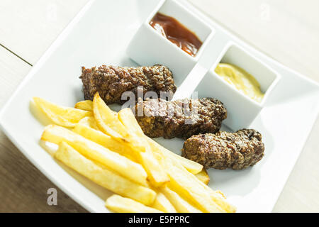 Traditionellen rumänischen Mici und Pommes Frites mit Ketchup und Senf hautnah Stockfoto