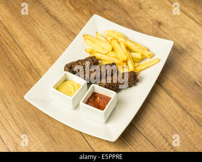 Traditionelle rumänische Speisen Frikadellen Mici und Pommes Frites mit Ketchup und Senf Stockfoto