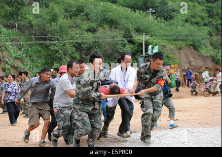 Ludian, der chinesischen Provinz Yunnan. 5. August 2014. Rettungskräfte tragen einen verletzten Mann an einem Hubschrauber in der Longtoushan Gemeinde Ludian County, der südwestlichen chinesischen Provinz Yunnan, 5. August 2014. Ein Hubrettung Kanal wurde nach dem Erdbeben der Stärke 6,5 in Ludian eröffnet. Bildnachweis: Tao Liang/Xinhua/Alamy Live-Nachrichten Stockfoto