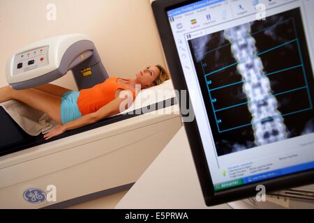 Ein Arzt benutzt ein Knochen Densitometer zur Messung der optischen Dichte der unteren Rachis (Backbone) der Patientin zu diagnostizieren Stockfoto