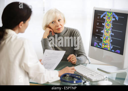 Arzt Rückgrat Densitometrie Röntgen mit einer Patientin zu diskutieren. Stockfoto