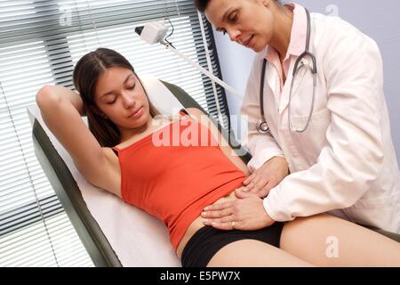 Ein Arzt untersucht den Bauch eines Mädchens durch Abtasten. Stockfoto