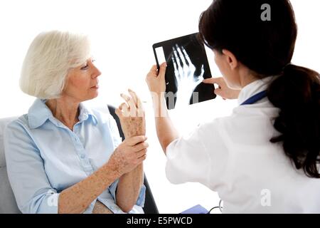 Arzt, die Hand Röntgen mit einer Patientin zu diskutieren. Stockfoto