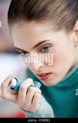 Frau mit einem Aerosol-Inhalator, der Erweiterung der Bronchien zur Behandlung von Asthma enthält. Der Inhalator weitet Lunge Atemwege Stockfoto