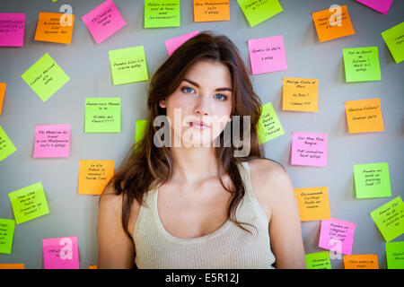 Frau umgeben von Post-It® Notes. Stockfoto