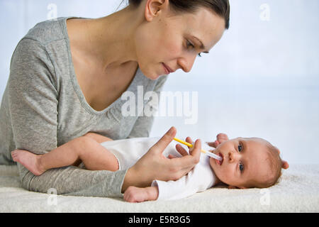 Mutter gibt ihr eines Monate altes Baby Vitamin D mit einer Pipette. Stockfoto