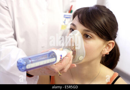 Frau durchläuft eine Lungenfunktion testen mit ein Peak-Flow-Meter um zu messen ihre exspiratorischen Flow, respiratorische Krankheiten Abteilung, Stockfoto