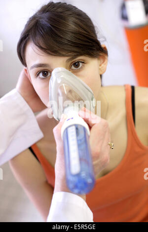 Frau durchläuft eine Lungenfunktion testen mit ein Peak-Flow-Meter um zu messen ihre exspiratorischen Flow, respiratorische Krankheiten Abteilung, Stockfoto