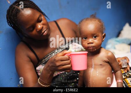 Junge Mutter und ihr Kind leidet an Unterernährung in einem therapeutischen Feeding Center in Monrovia, Liberia, umgesetzt durch Stockfoto