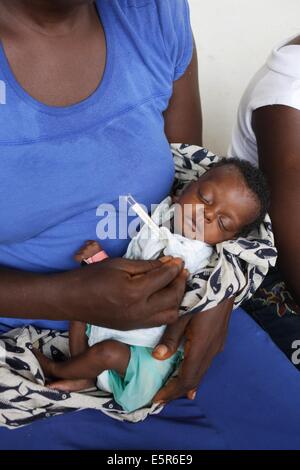 Überprüfen die Temperatur der Kinder leiden unter Mangelernährung in einem therapeutischen Feeding Center in Monrovia, Liberia, Stockfoto