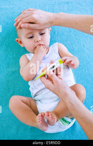 Mutter, überprüfen die Temperatur des fieberhaften 7 Monate altes Baby mit einem digitalen Thermometer. Stockfoto