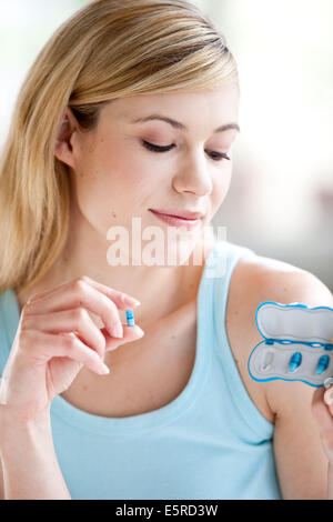 Frau, die Einnahme von Alli, Alli ist eine halbe Dosis-Version von der Diät Medikament Xenical (Orlistat) hergestellt von GlaxoSmithKline (GSK). Stockfoto