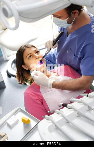 Zahnarzt mit UV-Licht eine lichtempfindliche Amalgam (Füllung) festlegen. Stockfoto