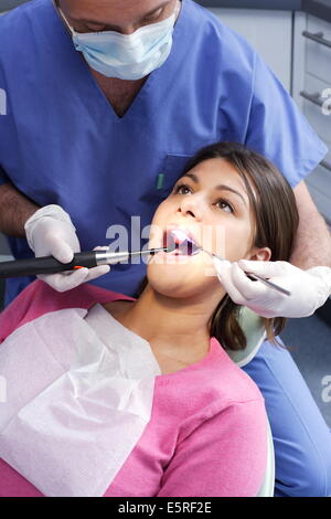 Zahnarzt mit UV-Licht eine lichtempfindliche Amalgam (Füllung) festlegen. Stockfoto