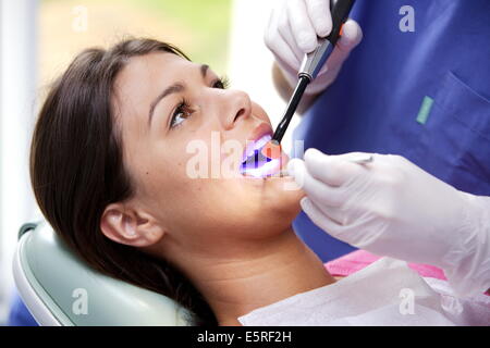 Zahnarzt mit UV-Licht eine lichtempfindliche Amalgam (Füllung) festlegen. Stockfoto
