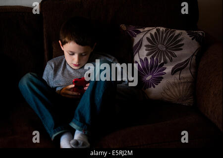 Jungen spielen auf dem Handy Stockfoto