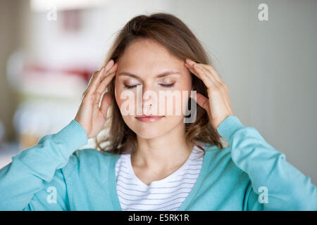 Frau geben sich selbst eine Tempel-Massage für Entspannung. Stockfoto