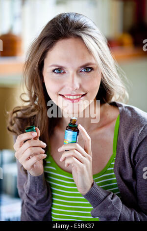 Frau eine Flasche ätherisches Öl riechen. Stockfoto