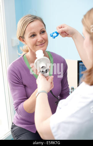 Frau durchläuft eine Lungenfunktion testen mit einem Spirometer, die den Höchstsatz misst an der Luft ausgeschlossen ist die Stockfoto