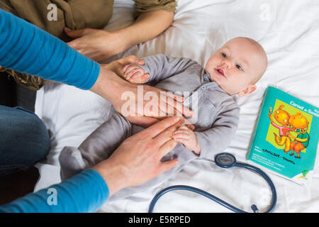 Arzt den Bauch ein 5 Monate altes Baby junge abtasten. Stockfoto