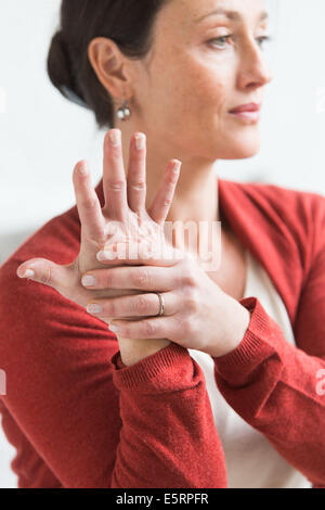 Frau geben sich selbst eine Hand-massage. Stockfoto