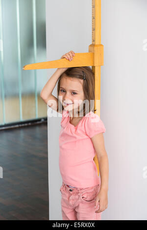 5-Year-Old Girl selbst an einem Höhe Messgerät messen. Stockfoto