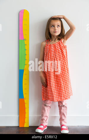 5-Year-Old Girl messen sich mit einer Höhe Spurweite. Stockfoto