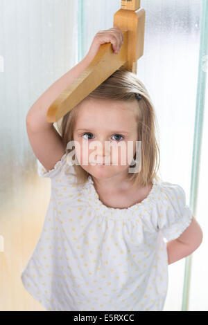 3-jährige Mädchen selbst an einem Höhe Messgerät messen. Stockfoto