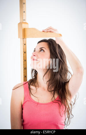 Frau unter Höhe Messgerät. Stockfoto