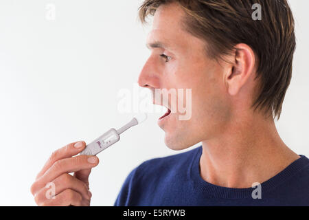 Mann mit Oraquick® HCV Hepatitis C Antikörper Schnelltest. Stockfoto