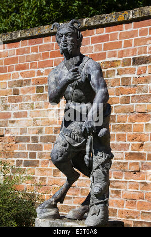 Pan Statue gegen einen roten Backsteinmauer Stockfoto