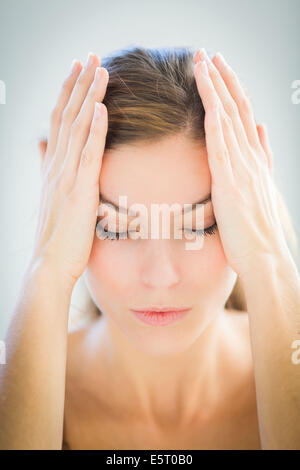 Frau geben sich selbst eine Tempel-Massage für Entspannung. Stockfoto