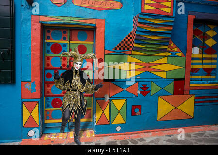 Carnivale kostümierten Narren im Eingang eines bunten Burano Haus in der Lagune von Venedig. Stockfoto