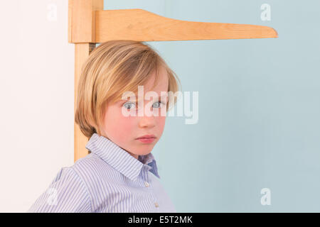 7-Year-Old Girl selbst an einem Höhe Messgerät messen. Stockfoto