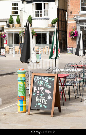 Tafel, Sonnenschirme, Tische und Stühle auf Bürgersteig vor UK Cafe bar Stockfoto